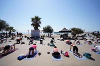 Prop d’un centenar de persones gaudeixen d’una classe grupal de ioga al passeig Marítim de Badalona